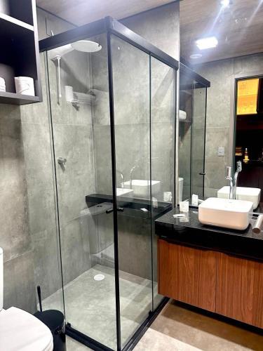 a bathroom with a glass shower and a sink at Apartamento Beira Mar NEW TIME 1014 in Maceió