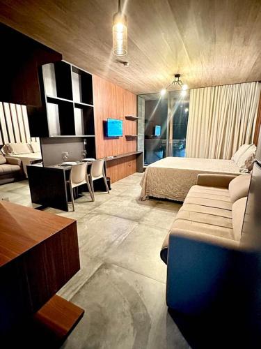 a bedroom with a bed and a desk and a couch at Apartamento Beira Mar NEW TIME 1014 in Maceió