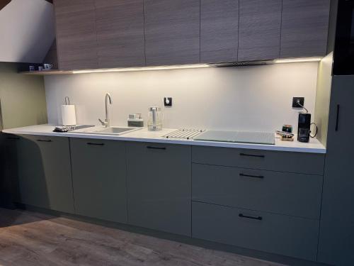 a kitchen with a sink and a counter top at Apartament Fyrtel in Poznań
