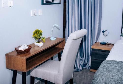 a desk in a bedroom with a bed and a desk with a chair at Emerald Inn in Letlhakane