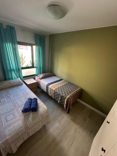 a bedroom with two beds and a window at Fuertevida in Caleta De Fuste