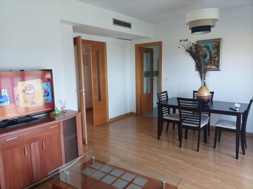 Precioso apartamento a minutos del metro في بيتيرا: غرفة معيشة مع طاولة طعام وتلفزيون