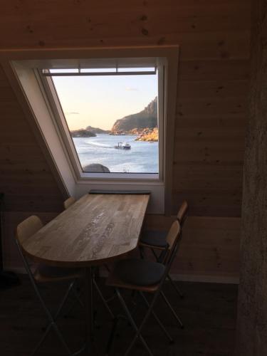 a table and chairs in a room with a window at Lofoten Sea Lodge in Sennesvik