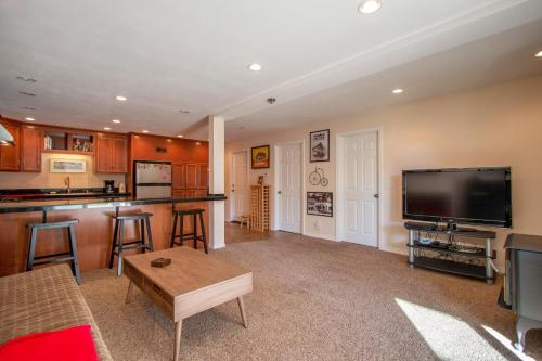 a living room with a flat screen tv and a kitchen at Northern Daylights in White Salmon