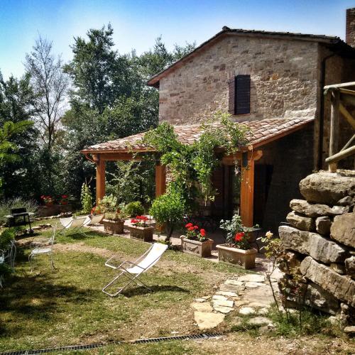 a group of chairs in front of a house at Agriturismo Casa Greppo in San Venanzo