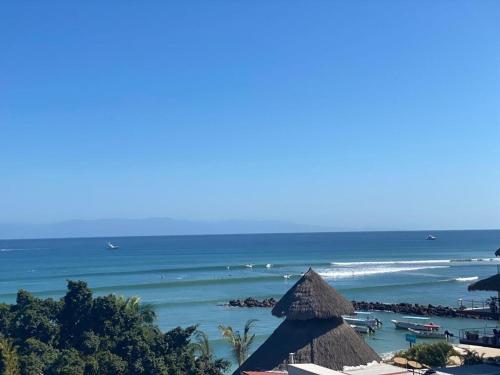 a beach with some umbrellas and the ocean at OCEAN VIEW GETAWAY! Penthouse Studio in Punta de Mita! in Punta Mita