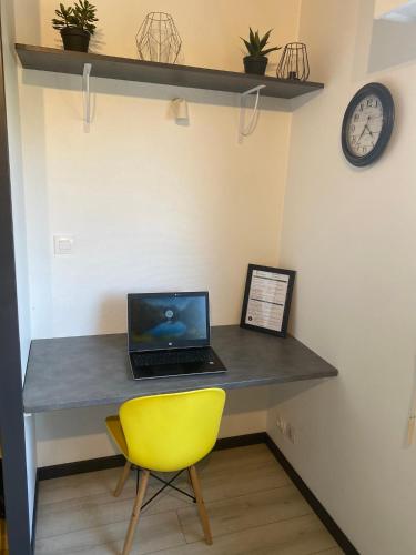 d'un bureau avec un ordinateur portable et une chaise jaune. dans l'établissement Le Delta - Centre CHU - parking privé - Netflix, à Poitiers