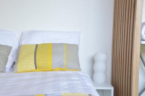 - une chambre avec un lit doté d'un oreiller jaune et gris dans l'établissement Le Delta - Centre CHU - parking privé - Netflix, à Poitiers
