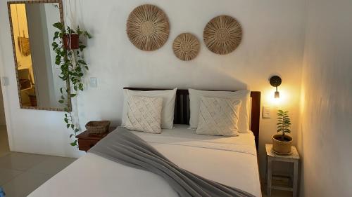 a bedroom with a bed with pillows and a mirror at Casa Free Wind Jeri in Jericoacoara