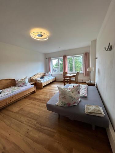 a living room with three beds and a table at Gäste- & Seminarhaus Mensch und Natur in Flammersfeld
