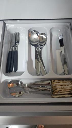 a drawer filled with silver utensils in a refrigerator at Apartamento Bandeiras Local Tranquilo e Familiar in Osasco