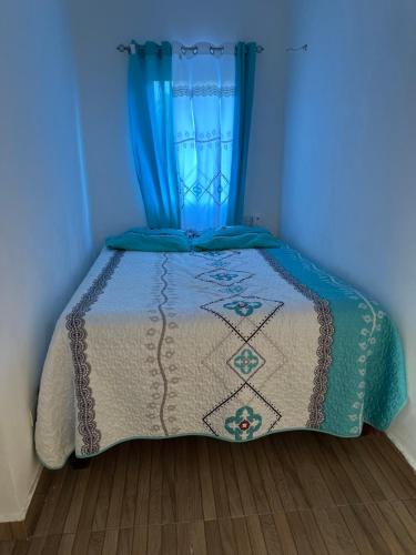 a blue bedroom with a bed with a blue curtain at Damaris Bed & Breakfast in Las Terrenas