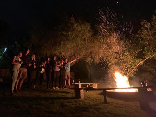 a group of people standing around a fire at The Ocean Bay Luxury Guesthouse in Jeffreys Bay