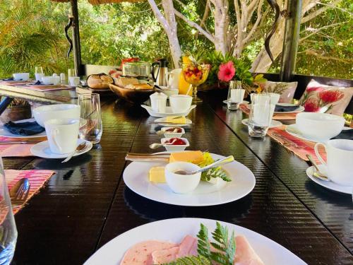 a long table with plates of food on it at The Ocean Bay Luxury Guesthouse in Jeffreys Bay
