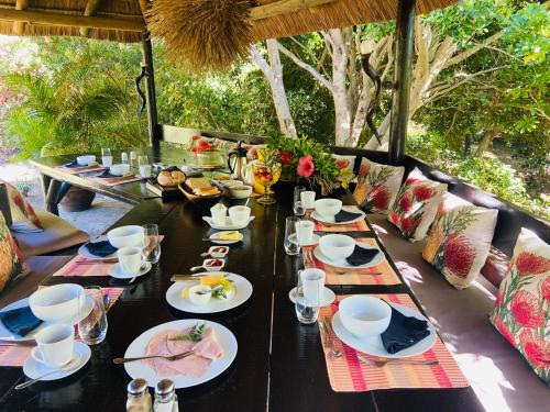 a black table with plates and dishes on it at The Ocean Bay Luxury Guesthouse in Jeffreys Bay
