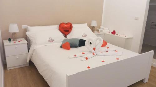 un letto bianco con un cuore rosso sopra di Elegante matrimoniale clemente house catania centro a Catania