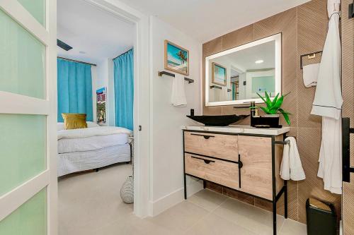 a bathroom with a sink and a mirror at 2-Min to Beach, Upscale Enclave in Miami Beach