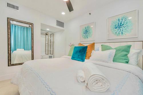 a bedroom with a large white bed and a mirror at 2-Min to Beach, Upscale Enclave in Miami Beach