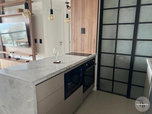 eine Küche mit einer Theke mit einem Weinglas darauf in der Unterkunft Pôr do Sol na Barra I in Salvador