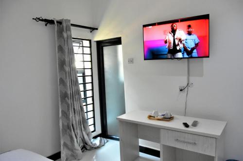 a living room with a tv on the wall at Alexandrina's Corner in Chipata
