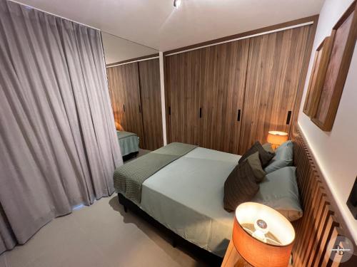 ein kleines Schlafzimmer mit einem Bett, einem Tisch und einem Fenster in der Unterkunft Pôr do Sol na Barra I in Salvador