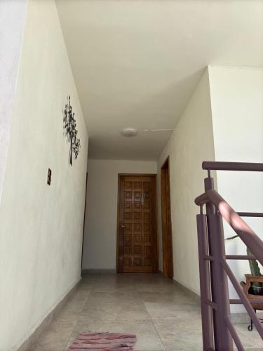 a hallway with a staircase and a wooden door at Estancias HGS in Santiaguito
