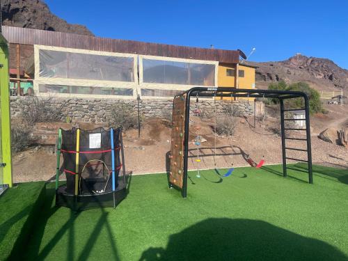 a play area with two swings on a playground at Cabañas Caleta Hueso in Taltal