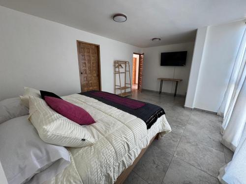 a bedroom with a bed with purple pillows at Estancias HGS in Santiaguito
