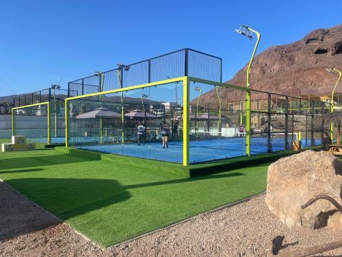 a glass building with a tennis court on a field at Cabañas Caleta Hueso in Taltal