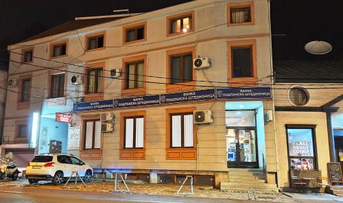 a white car parked in front of a building at Aleksei Apartmani in Belgrade