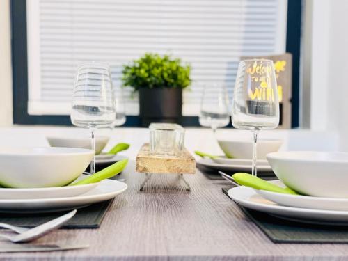 a wooden table with plates and wine glasses on it at Luxury City Centre Apartment in Edinburgh