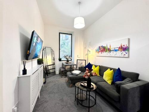 a living room with a couch and a flat screen tv at Luxury City Centre Apartment in Edinburgh