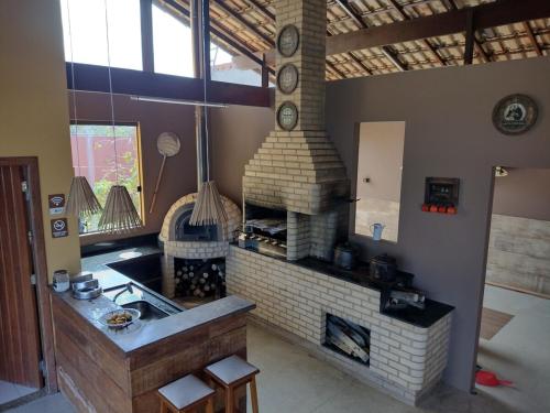 a kitchen with a brick fireplace in a room at Casa Amarela Praia Grande in Fundão