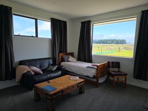 a living room with a couch and a bed and a table at The Opuha House in Ashwick Flat