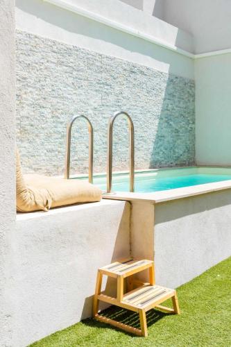 - une piscine avec un tabouret en bois à côté de l'aération dans l'établissement Charming city villa in the heart of Marseille, à Marseille