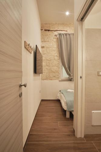 a small room with a bed and a window at La Home 1909 in Trani