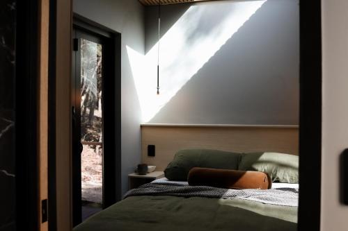a bedroom with a bed and a large window at SHAK Halls Gap - Off Grid Tiny Home in Halls Gap