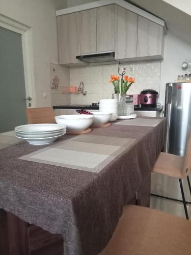 a kitchen with bowls and plates on a counter at Anagata House Batu at C8 Grand Kusuma Hill in Batu