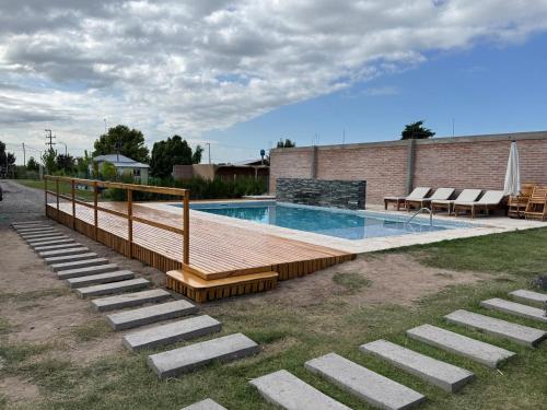 een zwembad met een houten terras naast een gebouw bij Cabañas Golden in San Rafael