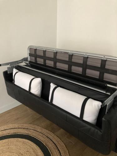 a black and white couch with white pillows at Studio centre proche marché et RER avec wifi in Saint-Germain-en-Laye