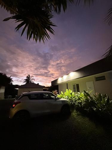 a white car parked in front of a building at Ononui Airport Studio in Faaa