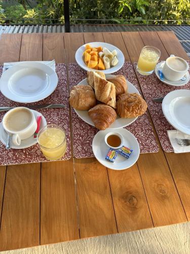 a table with plates of breakfast food on it at Ononui Airport Studio in Faaa