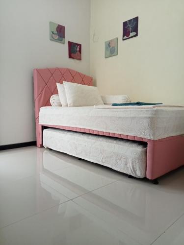 a bed with a pink headboard in a bedroom at Anagata House Batu at C8 Grand Kusuma Hill in Batu