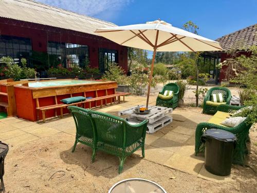 a patio with chairs and an umbrella and a pool at The White House by Casona Lo Aguirre - El Monte RM in Talagante