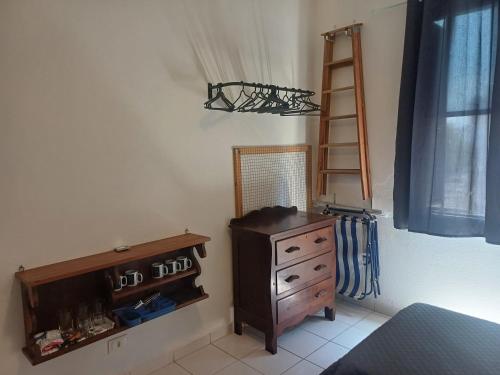 um quarto com uma cômoda, um espelho e uma prateleira em Apezito em Santos