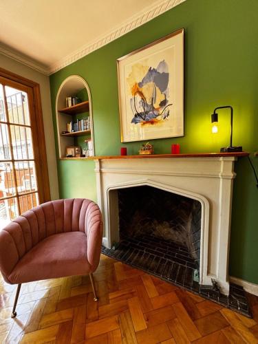 a living room with a chair and a fireplace at Hermosa casa en Barrio Pocuro con estacionamiento gratuito in Santiago