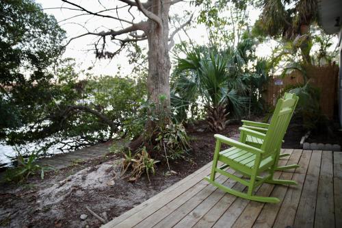 two green lawn chairs sitting on a wooden deck at Bamboo Bungalow - Waterfront Studio Near Beach in Cocoa Beach