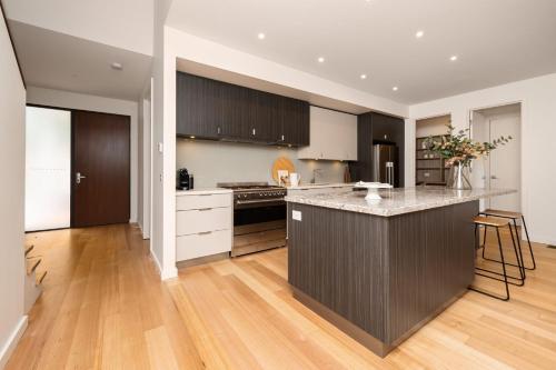 a kitchen with a island in the middle of a room at Aura Family Home by the Bay in Highett