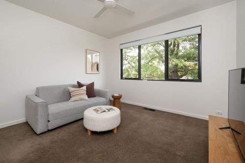 a living room with a couch and a window at Aura Family Home by the Bay in Highett