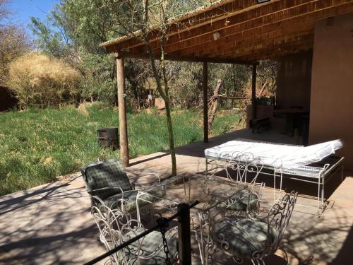 acovered patio with two beds and a table and chairs at Casa Luna in San Pedro de Atacama
